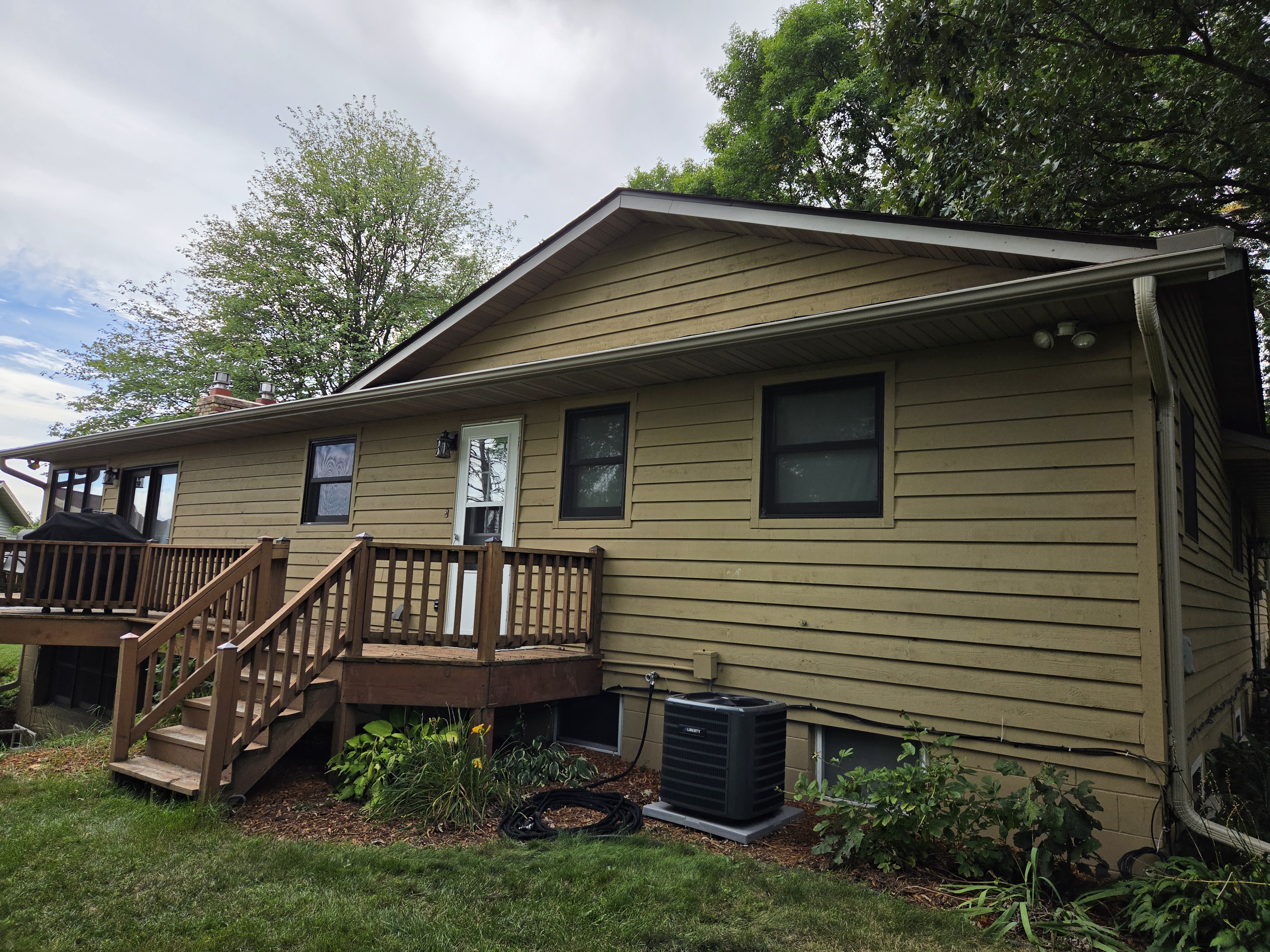 Gutters and a downspout along the rear of a tan-sided home