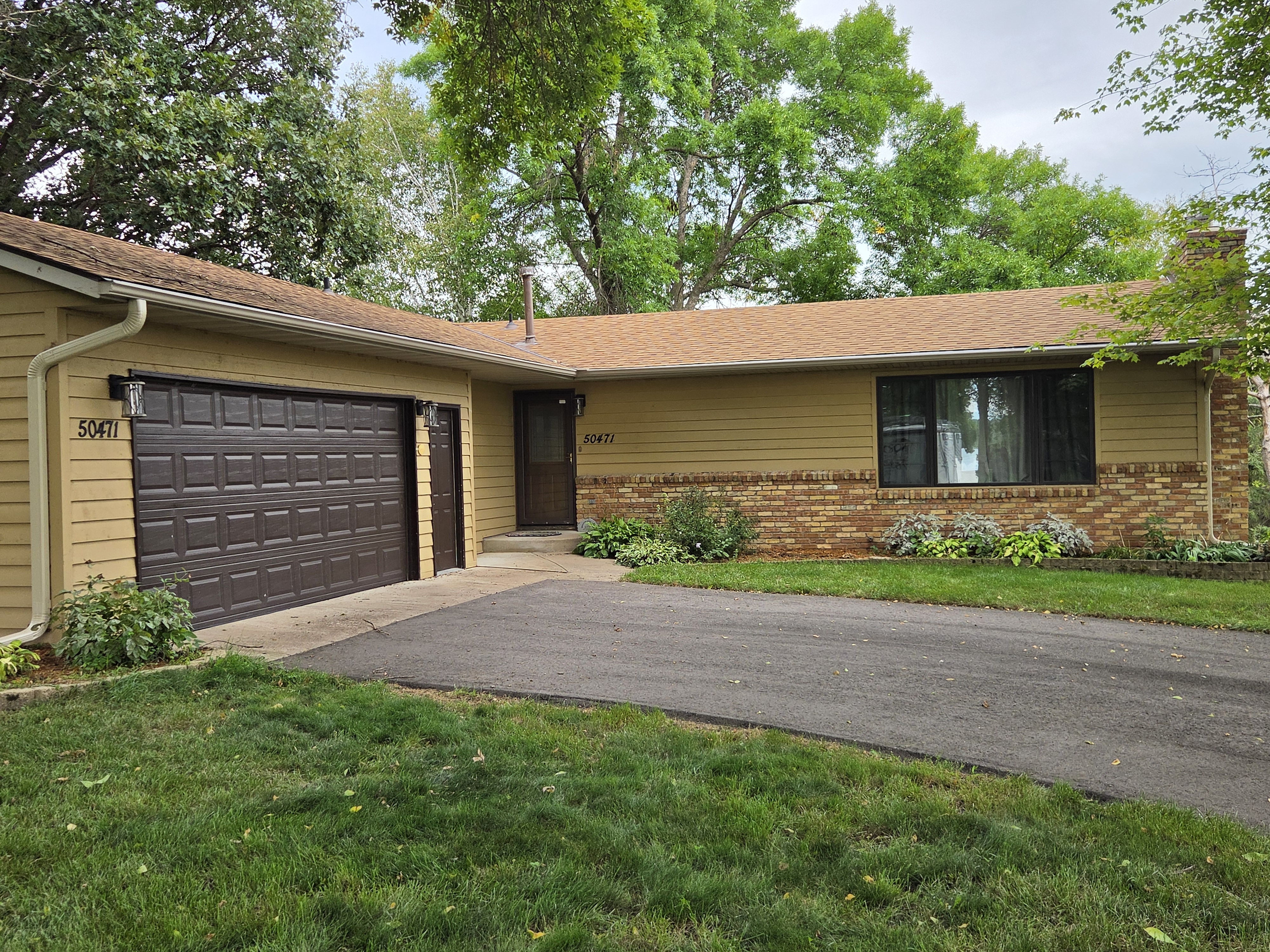 Front view of a single-story home and attached garage with gutters