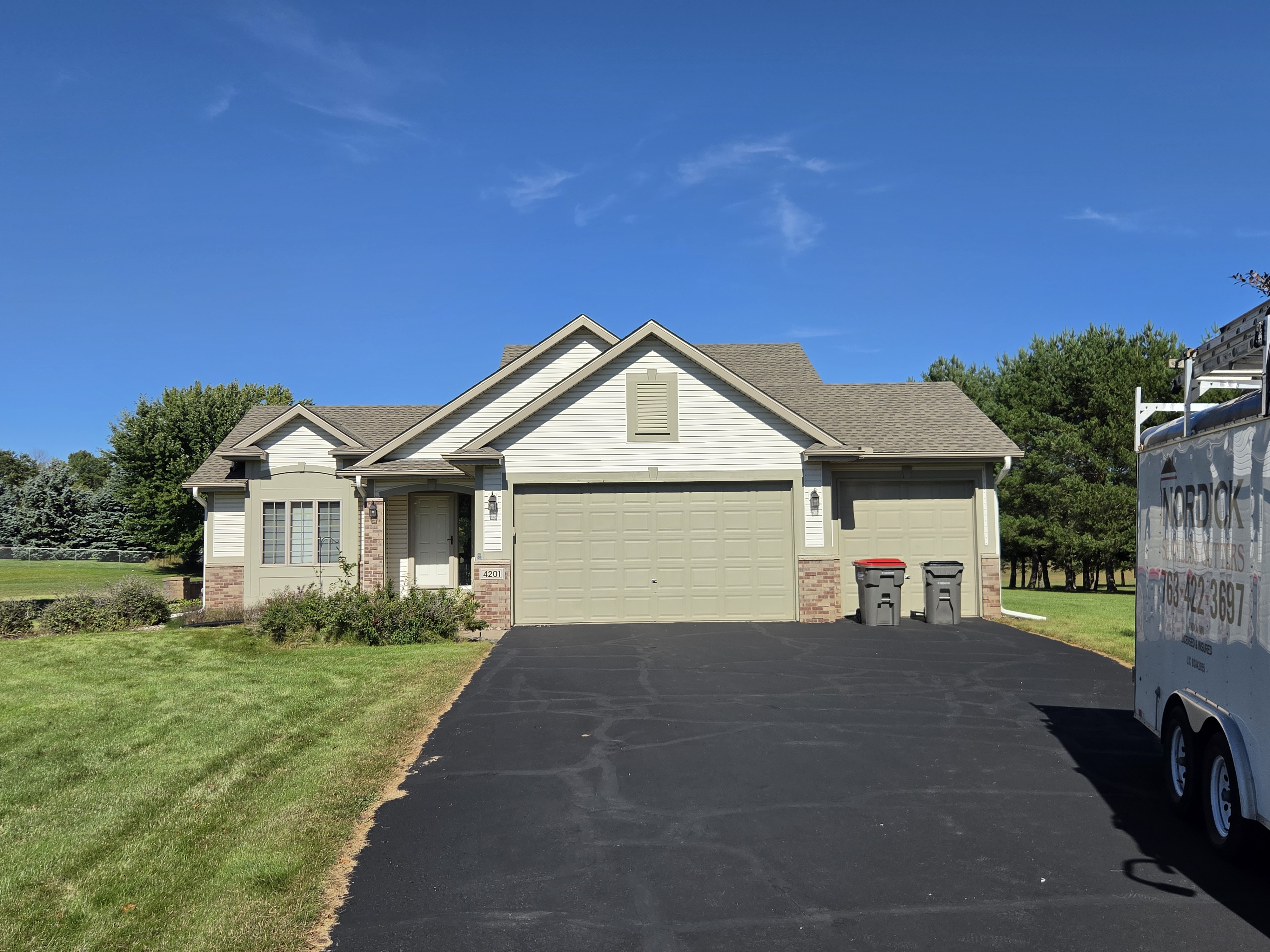 Front view of a single-story home with an attached garage and gutters